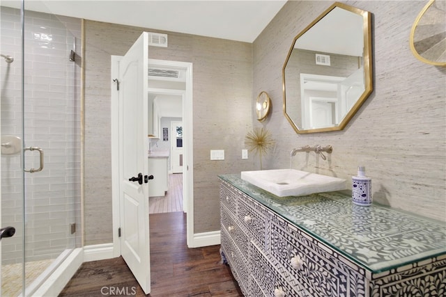 bathroom with a stall shower, visible vents, wood finished floors, and vanity