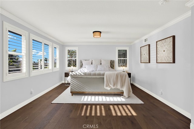 bedroom featuring baseboards, wood-type flooring, visible vents, and crown molding