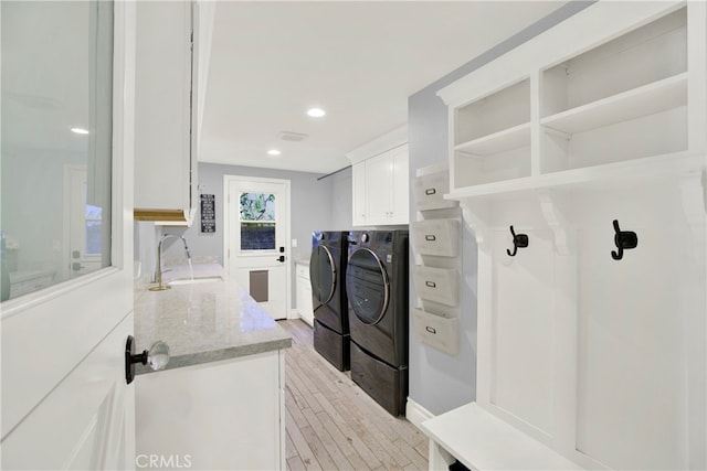 interior space with light wood-style flooring, recessed lighting, a sink, cabinet space, and washer and clothes dryer