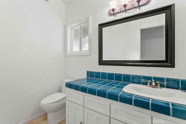 bathroom featuring toilet, vanity, and tile patterned floors