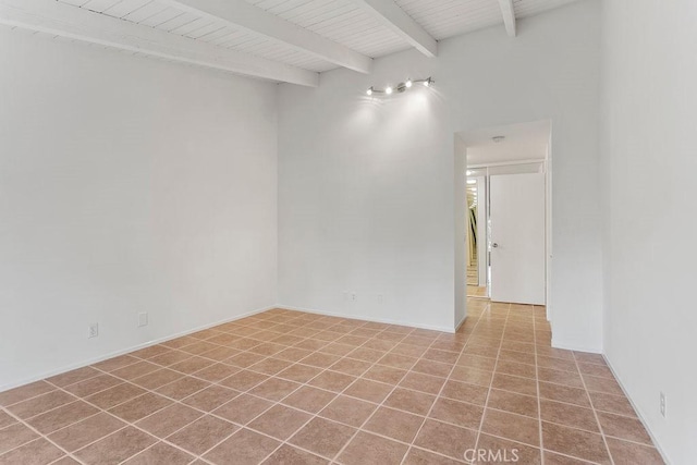 tiled spare room with beam ceiling