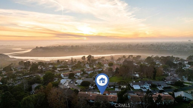 aerial view at dusk featuring a water view