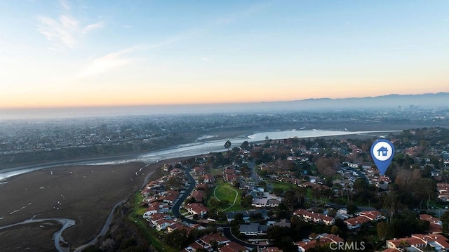 aerial view at dusk featuring a water view