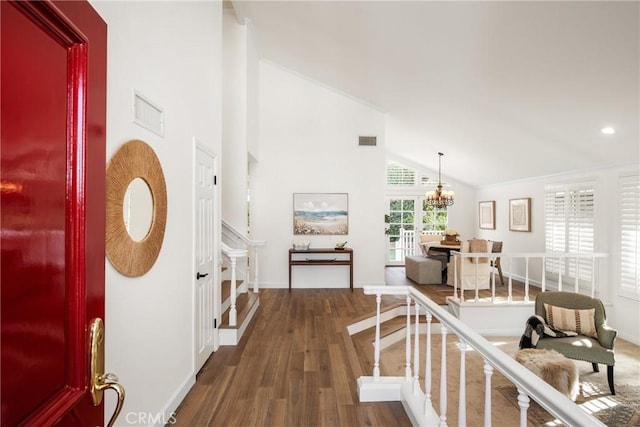 hallway with an inviting chandelier, dark hardwood / wood-style floors, and high vaulted ceiling