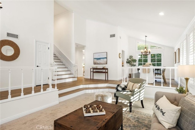 living room featuring high vaulted ceiling, an inviting chandelier, and carpet flooring