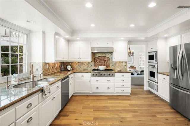 kitchen featuring appliances with stainless steel finishes, light wood-type flooring, light stone countertops, white cabinets, and sink