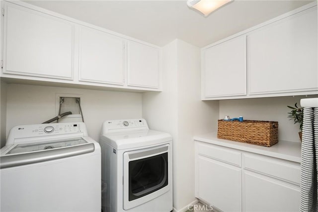 washroom with cabinets and washer and dryer