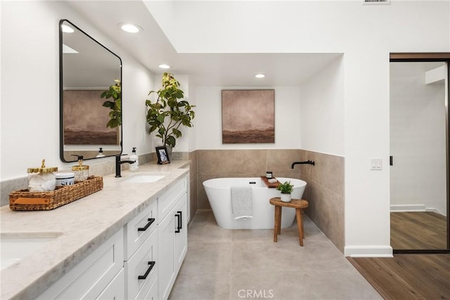 bathroom with vanity and a bath