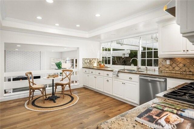 kitchen with white cabinets, dishwasher, dark stone counters, sink, and backsplash