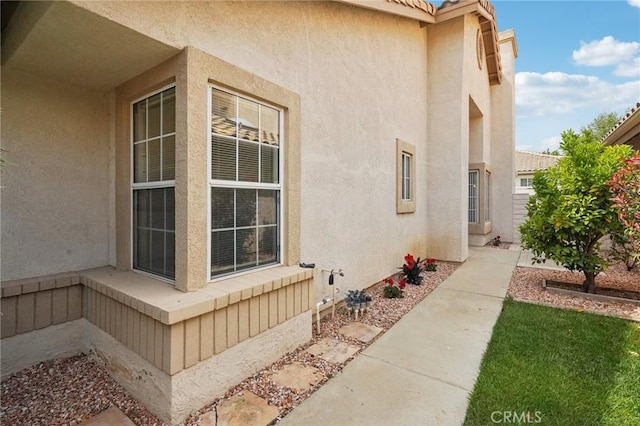 view of property exterior featuring a tiled roof and stucco siding