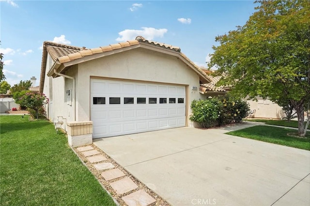 view of front of home with concrete driveway, stucco siding, a tiled roof, an attached garage, and a front yard