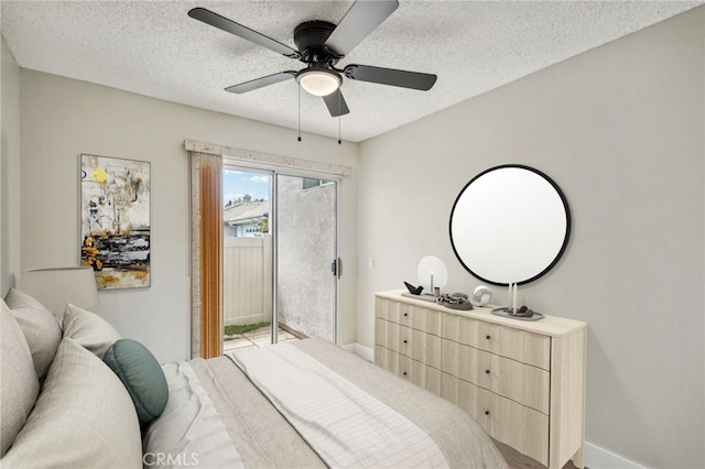 bedroom with a textured ceiling, access to outside, ceiling fan, and baseboards