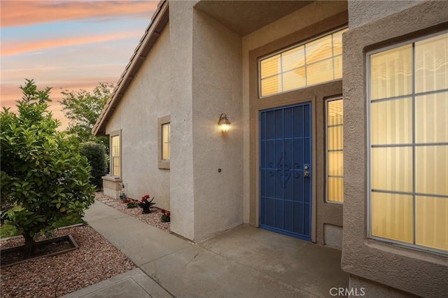 exterior entry at dusk with stucco siding