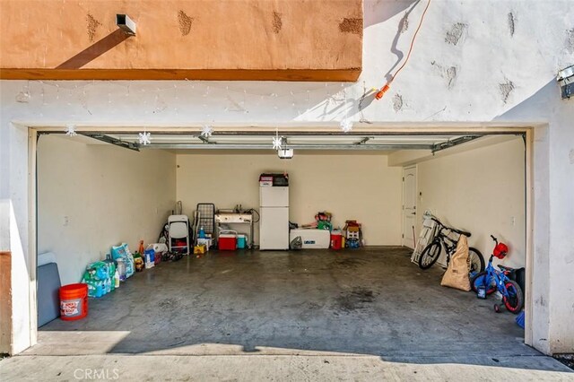 garage with white refrigerator and a garage door opener