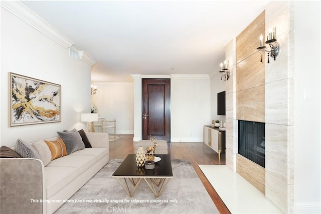 living room featuring light hardwood / wood-style floors, crown molding, and a premium fireplace