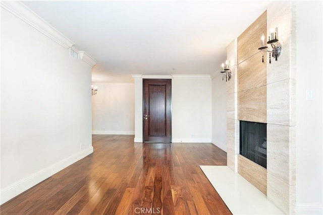 unfurnished living room with a tiled fireplace, dark wood-type flooring, and ornamental molding