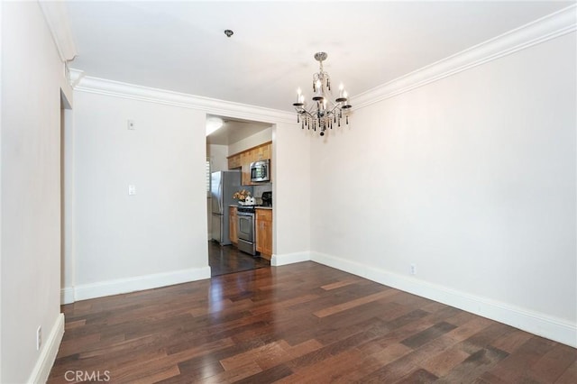 spare room with an inviting chandelier, crown molding, and dark hardwood / wood-style floors