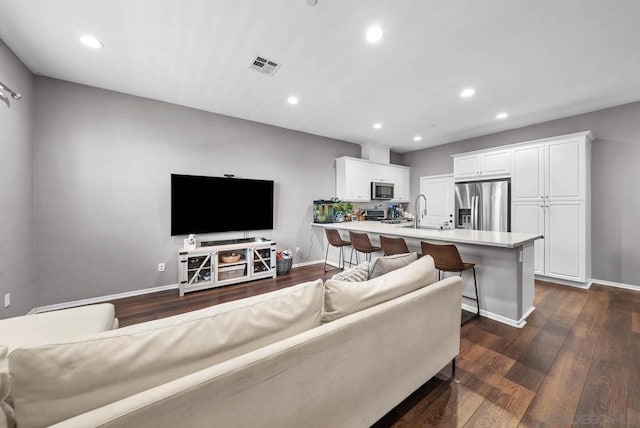 living room with dark hardwood / wood-style flooring and sink