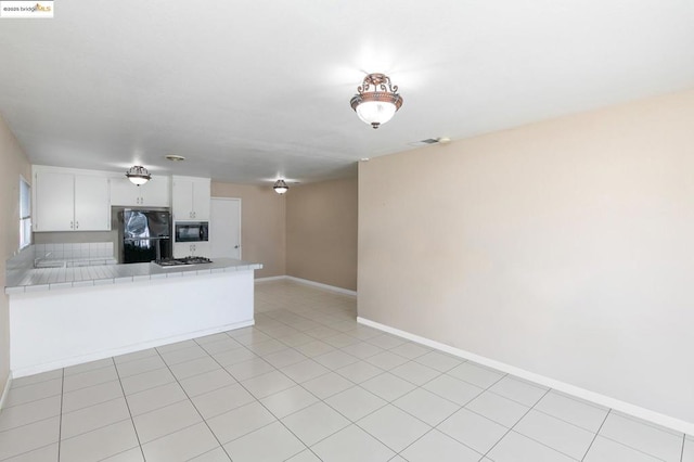 kitchen with white cabinetry, kitchen peninsula, tile counters, light tile patterned flooring, and black appliances