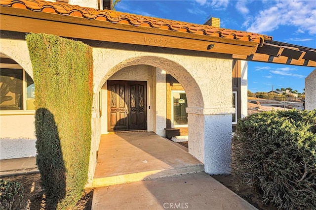 view of exterior entry featuring a patio