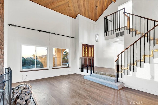 foyer entrance with high vaulted ceiling, wood ceiling, and hardwood / wood-style floors