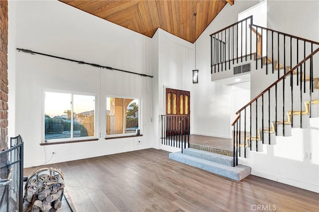 entrance foyer with hardwood / wood-style flooring, wood ceiling, and high vaulted ceiling