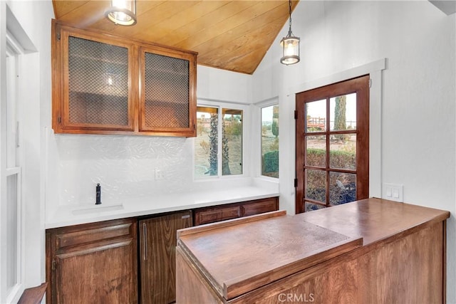 kitchen featuring decorative light fixtures, tasteful backsplash, wood ceiling, lofted ceiling, and sink