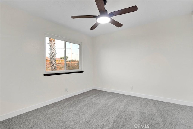 empty room featuring ceiling fan and carpet