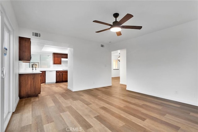 unfurnished living room with ceiling fan, light hardwood / wood-style flooring, and sink