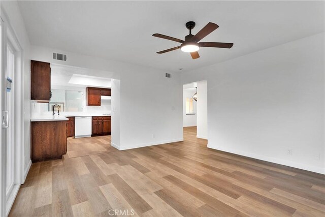 unfurnished living room with ceiling fan, sink, and light hardwood / wood-style floors