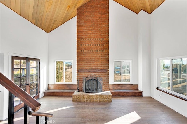 unfurnished living room featuring plenty of natural light, wooden ceiling, high vaulted ceiling, and french doors