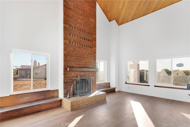 unfurnished living room featuring hardwood / wood-style flooring, plenty of natural light, a fireplace, and wooden ceiling