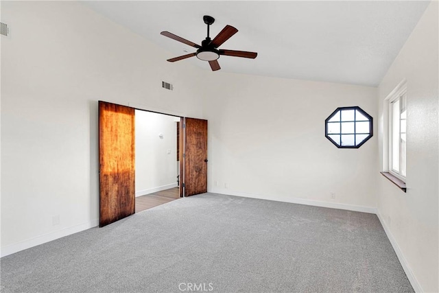 carpeted empty room with lofted ceiling and ceiling fan