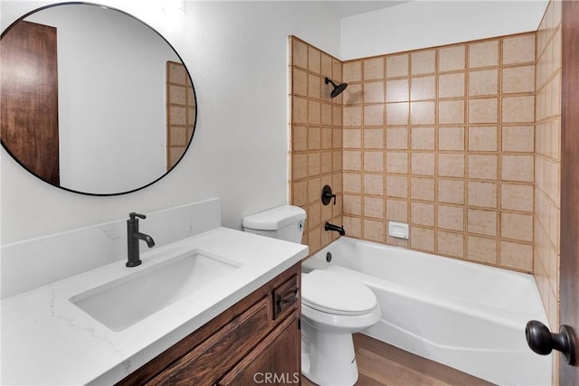 full bathroom featuring toilet, tiled shower / bath combo, and vanity