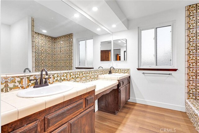 bathroom featuring backsplash, vanity, and wood-type flooring