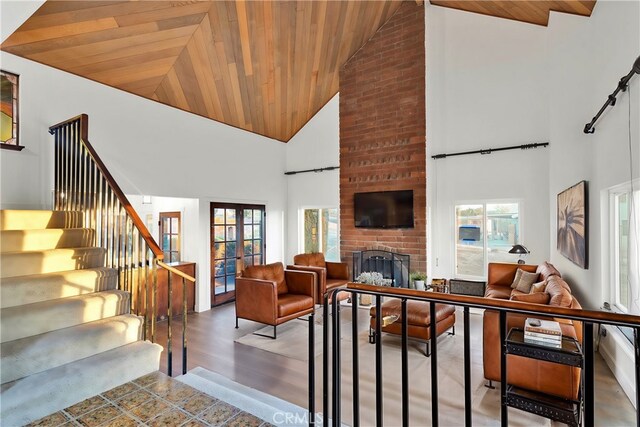 living room featuring a brick fireplace, high vaulted ceiling, and a wealth of natural light