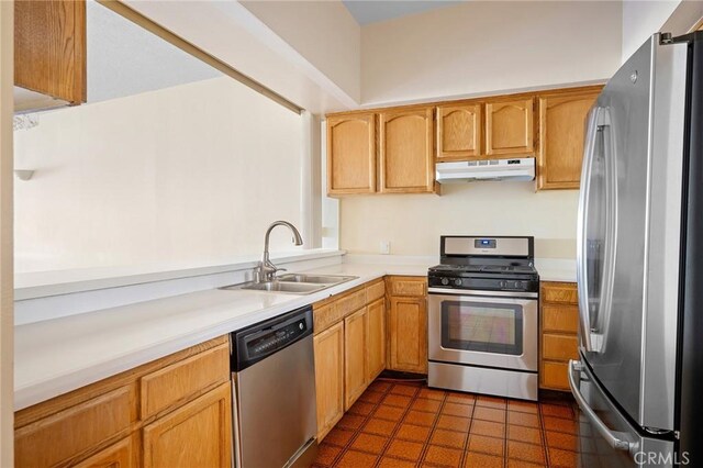 kitchen featuring appliances with stainless steel finishes, dark tile patterned floors, and sink