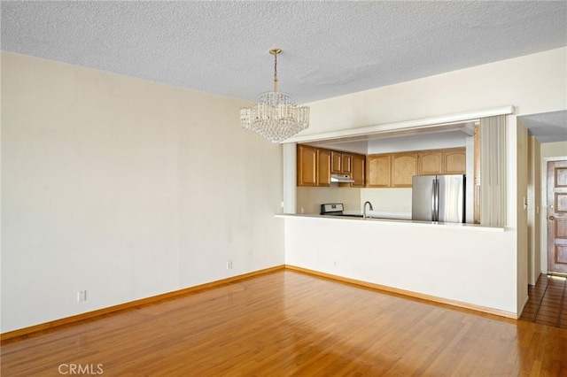 interior space featuring a notable chandelier, sink, a textured ceiling, and hardwood / wood-style floors