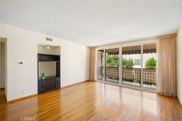 unfurnished room featuring a textured ceiling and hardwood / wood-style flooring