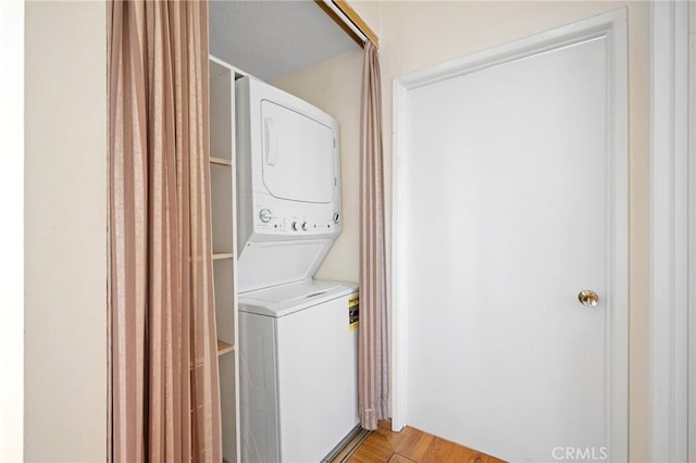 washroom featuring light hardwood / wood-style floors and stacked washer / dryer