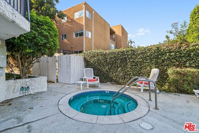 view of pool with a patio area and a hot tub