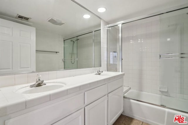 bathroom with bath / shower combo with glass door, tile patterned floors, tasteful backsplash, and vanity