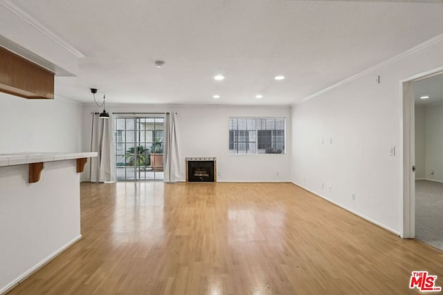 unfurnished living room featuring light wood-type flooring and crown molding