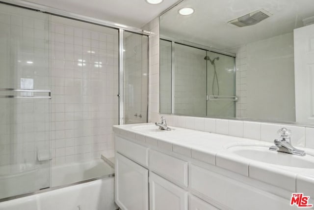 bathroom featuring shower / bath combination with glass door and vanity