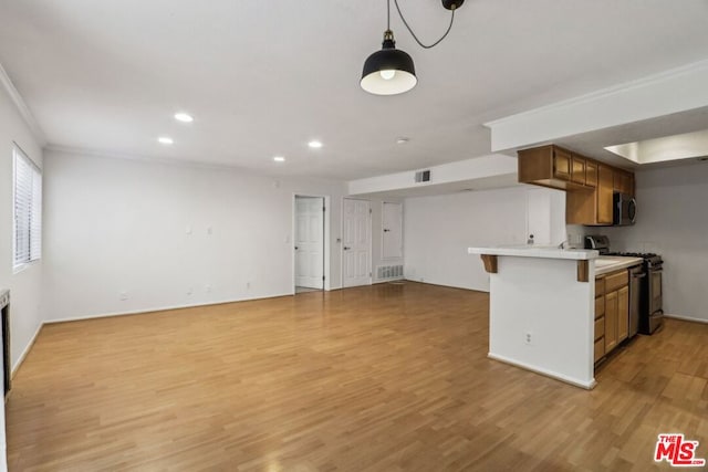 kitchen with black gas range, kitchen peninsula, decorative light fixtures, crown molding, and light hardwood / wood-style flooring