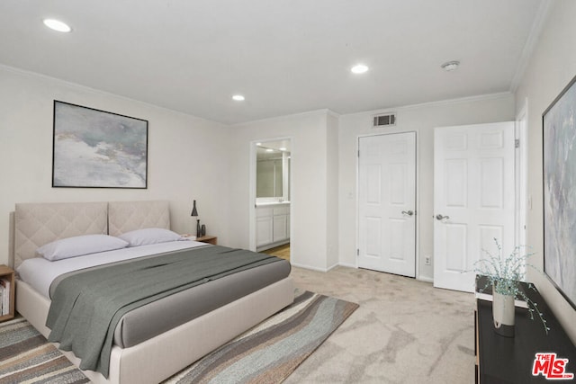 bedroom with crown molding, ensuite bathroom, and light carpet