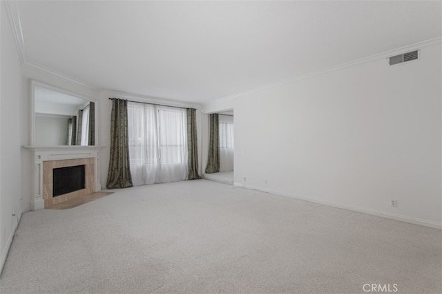 unfurnished living room with light carpet, ornamental molding, and a tile fireplace