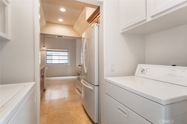 laundry room with washing machine and clothes dryer and cabinets