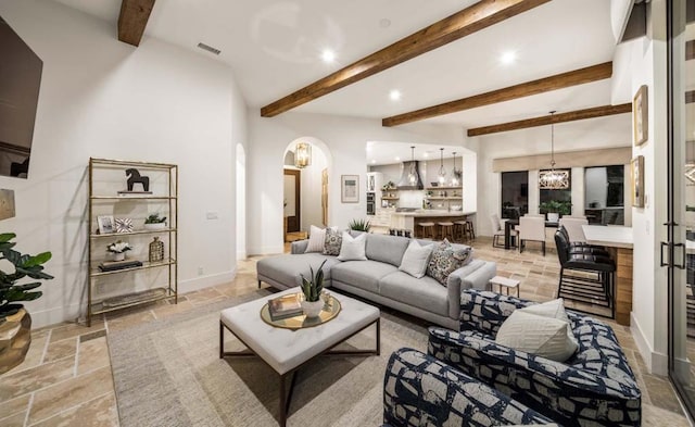 living room with a notable chandelier and beamed ceiling