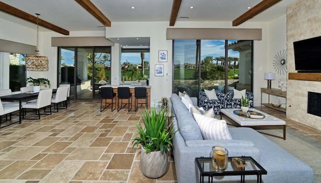 living room featuring a large fireplace and beam ceiling